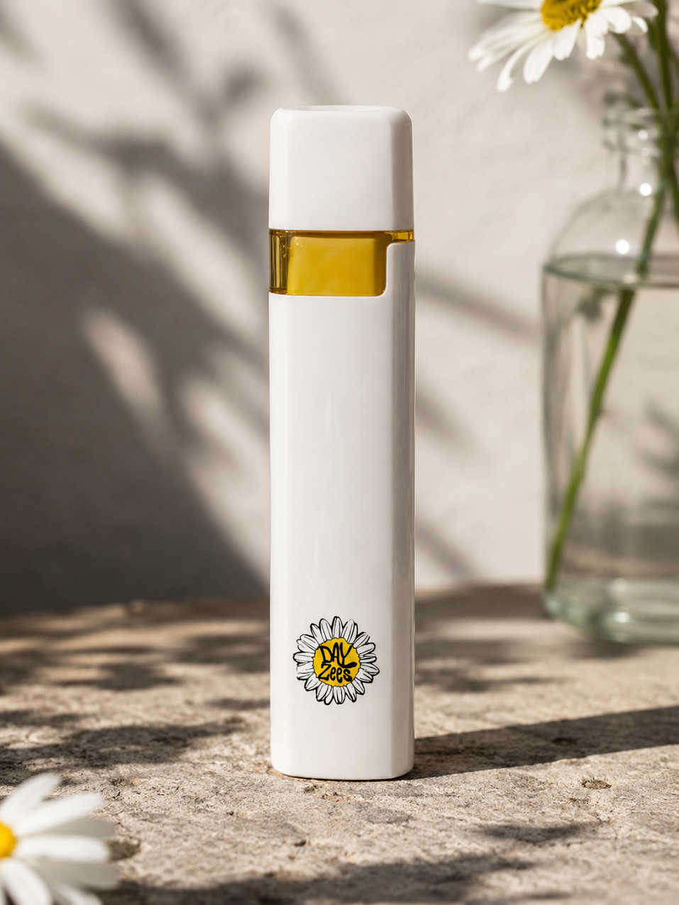 Dayzees solventless live rosin disposable vape standing beside white daisies